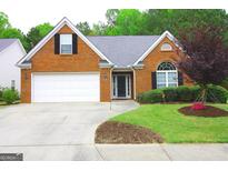 Charming single-Gathering home with a well-manicured lawn, brick facade, and two car garage at 25 Pacific Ave, Sharpsburg, GA 30277