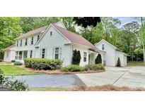 Charming white home with brown roof, featuring manicured landscaping and inviting curb appeal at 400 Peachtree Pkwy, Peachtree City, GA 30269