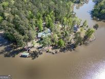 Stunning aerial view of lakeside home surrounded by lush trees and a private dock at 455 Mayo Rd, Covington, GA 30014