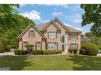 Charming brick two-story home with manicured lawn and mature trees, perfect for suburban living at 891 Berryman Pl, Lawrenceville, GA 30045