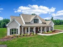 Stunning two-story brick home featuring a welcoming front porch and manicured lawn at 357 Old Driver Rd, Whitesburg, GA 30185