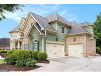 Beautiful home showcasing a combination of stone and siding exterior with a three-car garage at 3820 Preserve Crossing Ln, Cumming, GA 30040