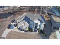 Stunning aerial view of a gray stone two-story home with a well-manicured lawn and ample parking at 116 Kalsum Trl, Ellenwood, GA 30294