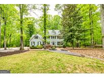 Charming two-story home with a manicured lawn and surrounded by lush greenery and mature trees at 120 Majesty Ln, Fayetteville, GA 30215