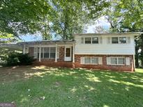 Charming two-story home with brick accents and a lush green lawn, shaded by mature trees at 6576 Randall Mark Dr, Morrow, GA 30260