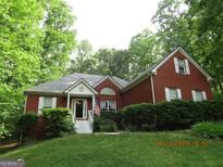 Charming single-Gathering home featuring brick facade, dormer window, and landscaped front yard at 25 Lake Charles Ct, Covington, GA 30016