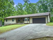Quaint single-Gathering home with a long driveway, attached garage, and well-maintained lawn at 110 Thompson Blvd, Stockbridge, GA 30281