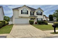 Charming two-story home featuring a well-manicured lawn, two-car garage, and classic curb appeal at 1130 Ivey Ln, Mcdonough, GA 30253