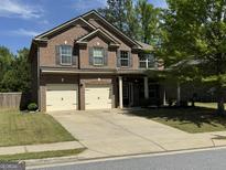 Two-story brick home with a two-car garage and a well-maintained front yard with a covered entryway at 960 Spanish Moss Trl, Loganville, GA 30052