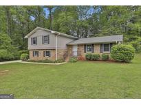 Charming split-level home featuring a brick facade, gray siding, and a well-manicured lawn at 269 Malone Cir, Fairburn, GA 30213