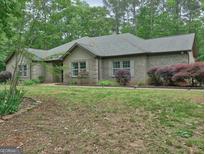 Charming brick home with a well-manicured lawn and lush landscaping at 678 Oak Grove Rd, Mcdonough, GA 30253