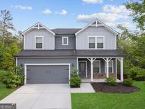 Charming two-story home with a covered porch, two-car garage, and manicured lawn at 1953 Azure Grove Ct, Marietta, GA 30008