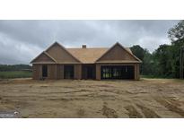 Exterior view of an unfinished house with a garage and wood construction material at 3229 Broadnax Mill Rd # 4, Loganville, GA 30052