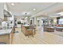 Open concept kitchen with large island, stainless appliances, and wood flooring at 215 Calgary Dr., Peachtree City, GA 30269