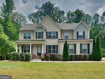 Charming two-story home features a landscaped yard and a welcoming front porch at 147 Tara Blvd, Loganville, GA 30052