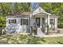 Charming one-story home featuring white siding, brown shutters, and a welcoming front porch at 1858 Ridgeland Dr, Decatur, GA 30032