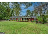 Charming brick home featuring a well-manicured lawn and classic design, perfect for suburban living at 1349 Springwood Nw Dr, Conyers, GA 30012