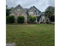 Beautiful brick home with well-manicured lawn and mature landscaping at 374 Persimmon Dr, Sharpsburg, GA 30277