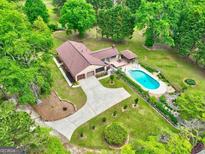 Stunning aerial view of a home featuring a pool, lush landscaping, and a long driveway at 171 Wynn Dr, Hampton, GA 30228