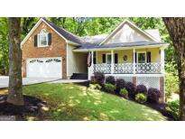 Charming home featuring a welcoming front porch, brick accents, and a well-manicured lawn at 139 Crown Forest Dr, Mcdonough, GA 30252