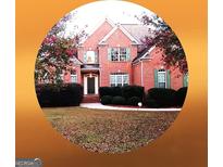 Traditional two-story brick home with a manicured lawn and mature landscaping at 30 Cynthia Ct, Fayetteville, GA 30215