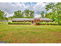 Charming single-story brick home with a well-manicured front yard and lush landscaping at 110 Silver Leaf Dr, Fayetteville, GA 30214