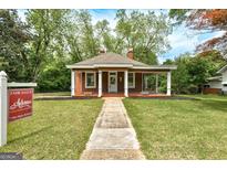 Charming single story house with a quaint front porch and well-manicured lawn at 19 Mcdonough St, Hampton, GA 30228