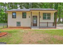 Charming home featuring a covered front porch, neutral siding, and well-maintained landscaping at 6454 Boca Grande Blvd, Forest Park, GA 30297