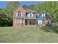Charming two-story home with a combination of brick and siding and a well-manicured lawn at 1310 Yarborough Dr, Peachtree City, GA 30269