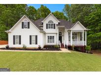 Charming two-story home featuring a manicured lawn, mature trees, and inviting front porch at 190 Ridgecrest Dr, Fayetteville, GA 30215