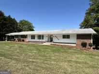 Charming one-story home with a well-manicured lawn and brick accents at 8315 Ridge Rd, Fairburn, GA 30213