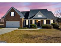 Charming brick home featuring a well-manicured lawn and inviting entrance with a wreath-adorned door at 3226 Puritan Way, Mcdonough, GA 30252