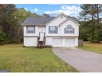 Charming two-story home featuring a well-manicured lawn and a double garage, perfect for Gathering living at 470 Old Griffin Rd, Hampton, GA 30228
