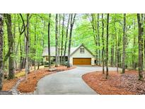 Charming home nestled amongst trees with a private driveway and a two-car garage at 145 Flat Creek Ct, Fayetteville, GA 30214
