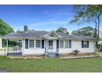 Charming single-story home with white siding, black shutters, and well-maintained lawn at 1236 Stone Mountain Lithonia Rd, Lithonia, GA 30058