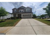 Charming two-story home with a well-manicured front lawn and a two-car garage at 883 Ironhorse Sw Ln, Mableton, GA 30126
