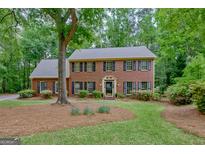 Charming two-story brick home featuring classic black shutters and a beautifully landscaped front yard at 120 Hermitage Pl, Peachtree City, GA 30269