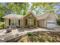 Charming home featuring a cozy patio with fire pit and seating, perfect for outdoor relaxation and entertaining at 5045 Edinborough Pl, Sugar Hill, GA 30518