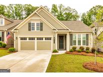 Charming home featuring a two-car garage, manicured lawn, and a welcoming front porch at 444 Silverbell Ct, Peachtree City, GA 30269