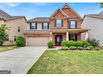 Charming two-story brick and tan home with a manicured lawn and attached two-car garage at 3259 Baylor Cir, Mcdonough, GA 30253