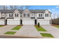 Attractive new construction townhomes feature painted brick and siding, a two-car garage, and manicured landscaping at 322 Sound Cir # 118, Stockbridge, GA 30281
