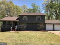 Charming two-story home with a combination of stone and wood siding and an attached two-car garage at 275 Summertown Dr, Stockbridge, GA 30281