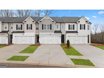 Inviting townhouse exteriors featuring attached garages, well-manicured lawns, and neutral color schemes at 334 Sound Cir # 120, Stockbridge, GA 30281