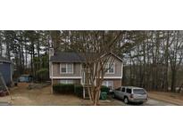 Two-story home with neutral siding, brick accents, and a well-maintained front yard, nestled amongst lush trees at 2443 Shoals Ter, Decatur, GA 30034