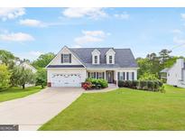 Charming two-story home featuring a well-manicured lawn and attached two-car garage at 447 W Wind Dr, Villa Rica, GA 30180