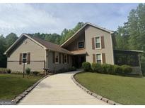 Charming home with light siding, shutters, and a beautifully maintained front yard surrounded by lush trees at 1685 Bailey Creek Sw Rd, Conyers, GA 30094