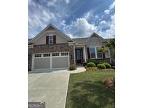 Charming single-story home featuring a brick facade, a two-car garage, and well-maintained landscaping at 619 Tulip Poplar Dr, Peachtree City, GA 30269