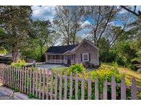 Charming single Gathering home with a picket fence, mature trees, and well maintained landscaping at 2228 Emory Sw St, Covington, GA 30014