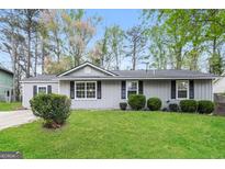Charming single-story home featuring a well-manicured lawn and fresh landscaping at 1427 Timms Se Cir, Atlanta, GA 30316