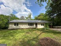 Ranch-style home with metal roof, painted brick accents, and a lush front lawn at 132 N Johnson St, Bowdon, GA 30108